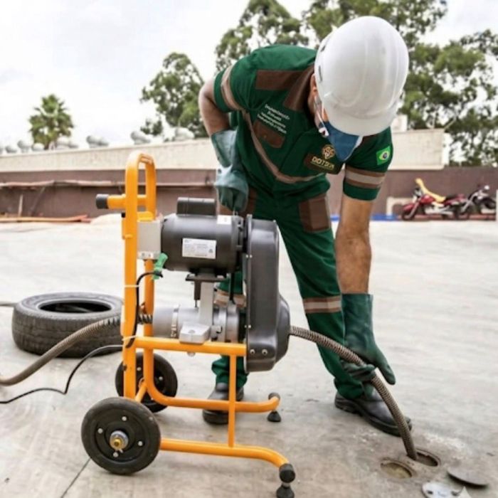 Equipe profissional realizando serviço de desentupimento